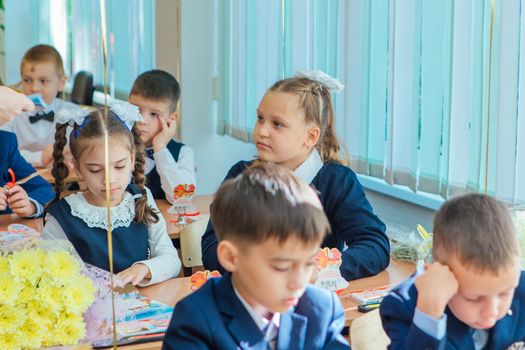 NOVOKUZNETSK, KEMEROVO REGION, RUSSIA - SEP, 1, 2021: First-grade students and teacher are in school classroom at first lesson. The day of knowledge in Russia.