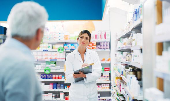 What symptoms do you have. a pharmacist assisting a customer in a chemist.