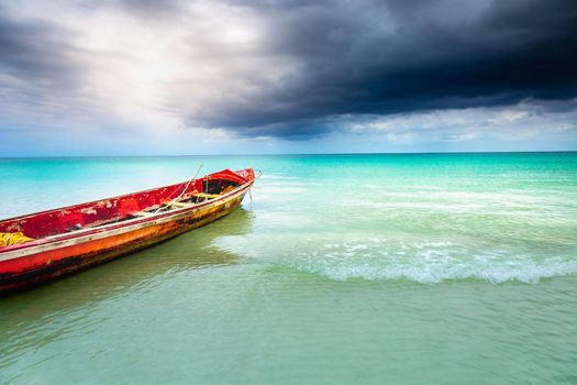 Dramatic sky over beach with motorboat, Negril Seven Mile Beach, Jamaica