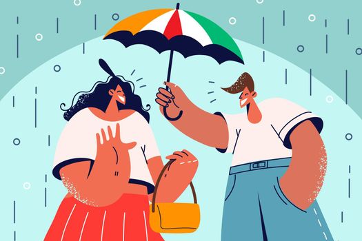 Smiling man cover woman with umbrella