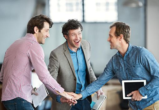 Hands in a huddle as a business man and his colleagues or coworkers cheer and celebrate success, a win or career achievement. Cheering and celebrating victory as a team or group in their work office