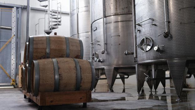 Huge tanks in wine cellars and wooden barrels of wine or alcohol