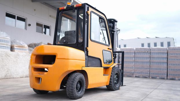 Reliable yellow forklift in warehouse. Loader in large outdoor warehouse