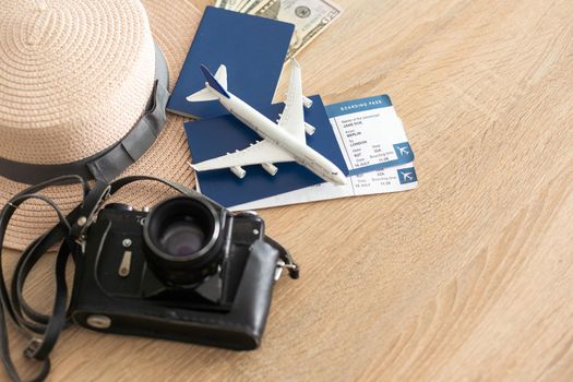 Travel concept. Airplane model, camera and passport on the table.