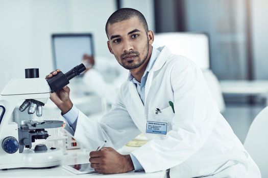 Vision, discovery and thinking scientist leading with innovation and modern science in lab. Portrait of young biologist analyzing medical sample with microscope, on mission for cancer or corona cure