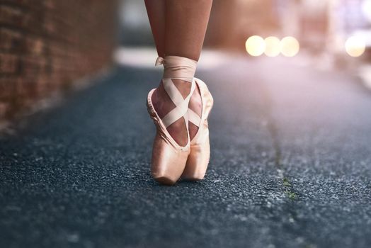 The heart of a dancer lies at her feet. a ballet dancer standing on tiptoes against an urban background.