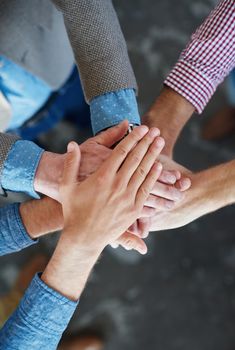 Support, teamwork and community by hands joining together during team building from above. Closeup of businesspeople doing stacked gesture, showing collaboration in pursuit of goal or success