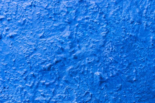 Irregular Bronze surface covered with blue paint.