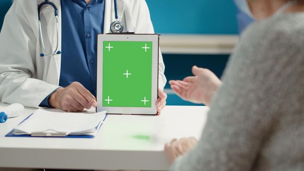 Medical specialist holding digital tablet with greenscreen