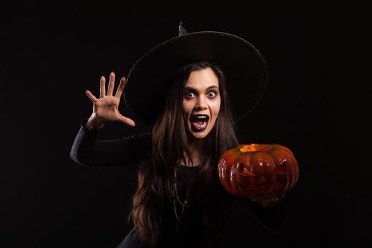 Caucasian young woman dressed up like a witch and screaming to the camera
