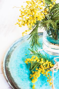 Table setting with sprig mimosa flowers