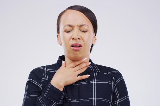 It hurts so bad every time I cough. Studio shot of a young woman suffering with a sore throat against a grey background.