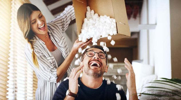 Its really snowing in here hey. a mature couple having fun with foam packaging balls while moving house.