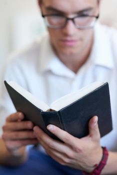 Always find time to connect with your beliefs. a handsome young businessman reading his bible at work.