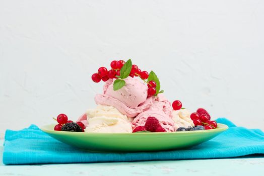 Vanilla and raspberry ice cream scoops on a round green plate