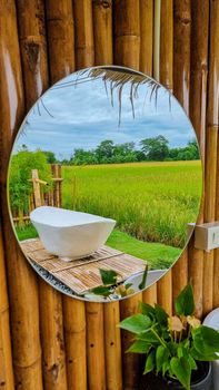 white bath tub outside on vacation at a homestay in Thailand with green rice paddy field