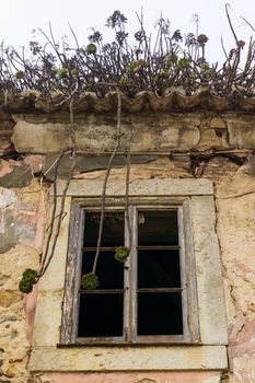 Bottom view of an empty dark window of an old abandoned house
