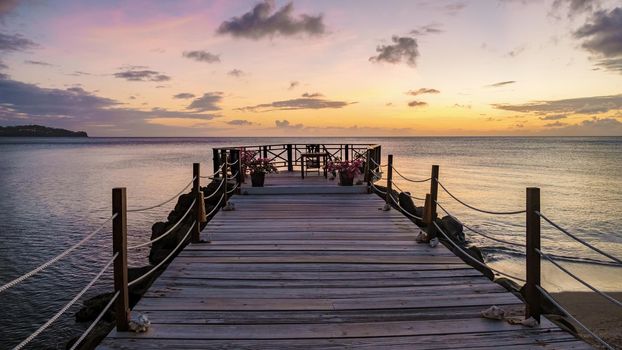 wooden pier in the ocean during sunset at Saint Lucia or St Lucia Caribbean