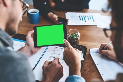 Green screen, copyspace and chromakey on a tablet screen in the hands of a business man in a meeting in a boardroom. Advertising, marketing and online promotion with colleagues pointing at copyspace
