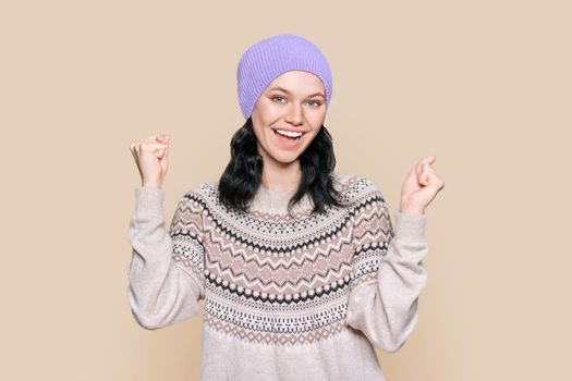 Portrait of happy young woman in sweater hat celebrating winter holidays
