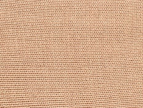 Beige knitted pattern background. Crochet fabric texture