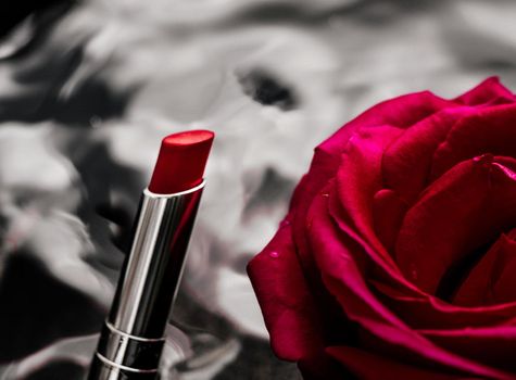 luxe red lipstick and a wonderful rose - make-up and cosmetics styled beauty concept