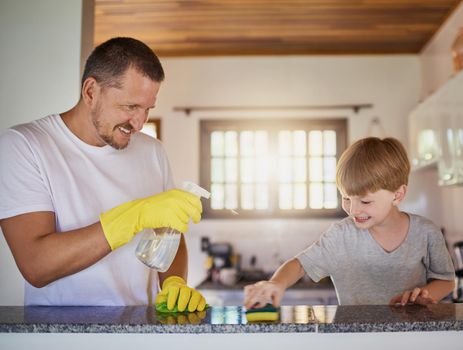 Teaching kids responsibility begins at an early age. a father and his little son doing chores together at home.