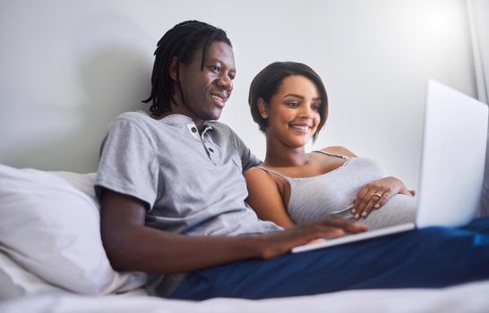 Lets check what this week of pregnancy holds. an expecting couple browsing the internet at home.
