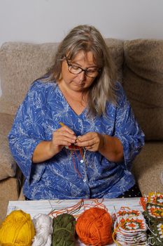older white-haired woman crocheting