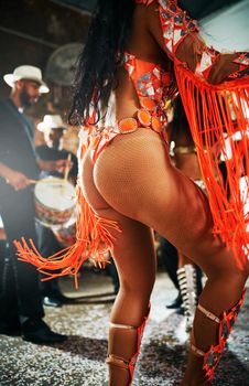 Shake dat ting. a beautiful samba dancer performing in a carnival with her band.