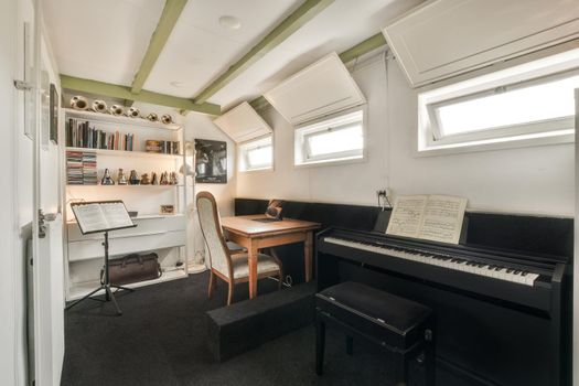 Spacious study room with table, shelves and piano