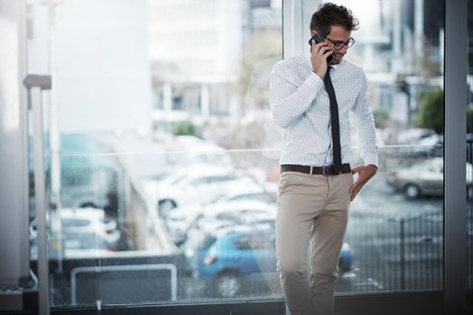 Stay connected, stay successful. a young businessman talking on a cellphone in an office.