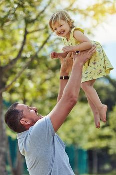 Give them wings and let them fly. a father bonding with his little daughter outdoors.