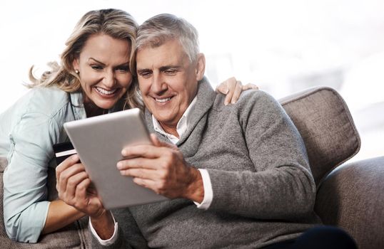 Theres just a whole lot more to browse when shopping online. a mature couple using a digital tablet and credit card to do online shopping at home.