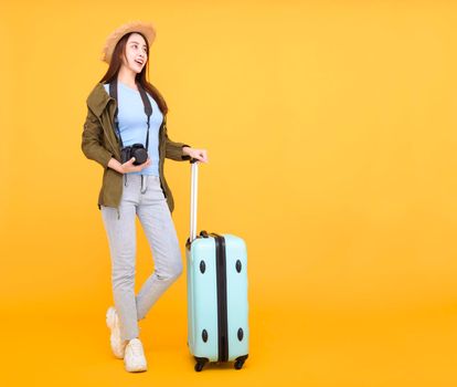 Happy young woman with luggage and camera isolated on yellow background ,autumn,travel concept.