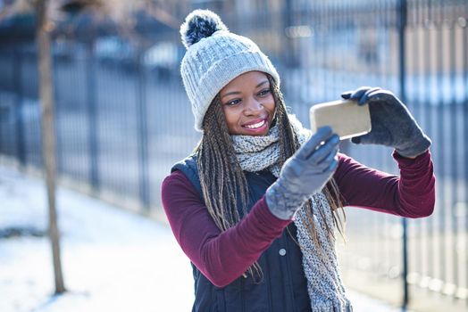 The first selfie of the snowy season. a beautiful young woman taking a selfie on a snowy day outdoors.