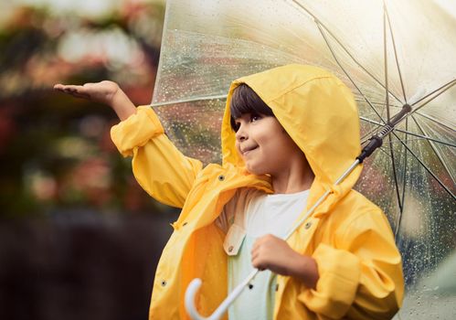 Rainy weather is my favourite type of weather. an adorable little boy in the rain outside.