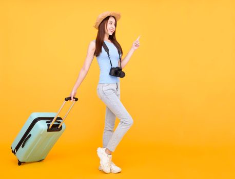 Happy young woman with luggage and camera isolated on yellow background ,summer,travel concept.