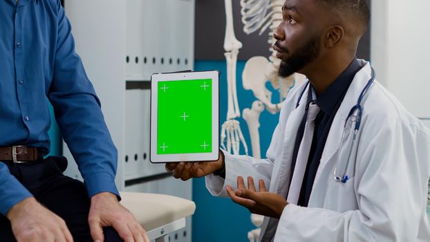 Doctor and elderly patient looking at greenscreen display