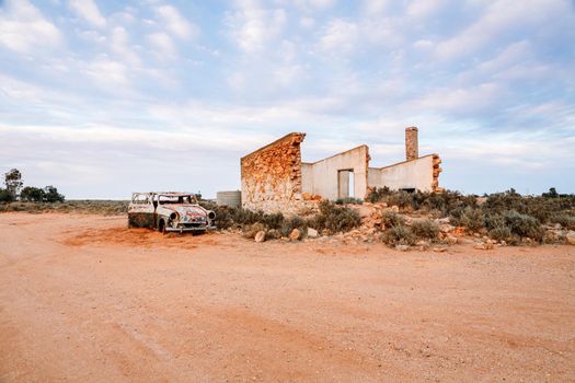 Crumbling old stone homes and rusting cars in outback Australia