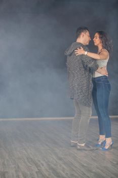 Attractive young man dancing with his girlfriend in dancing class