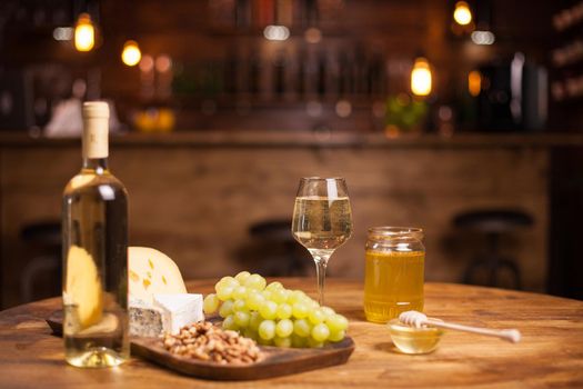 Photo of various wine snacks on wooden table in a vintage pub