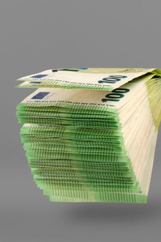 A large stack of 100 euro banknotes on a uniform gray background. Stack of banknotes as a concept of a loan, insurance payment, high income or mortgage