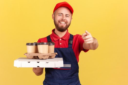 Deliveryman with pizza and coffee in disposable cup pointing at camera door to door delivery service
