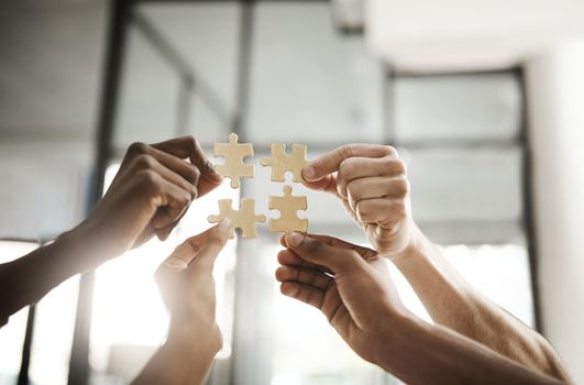 Business people hands with puzzle showing solution, problem solving and teamwork. Smart group or team activity completing, finishing a task project or assignment in difficult challenging work crisis