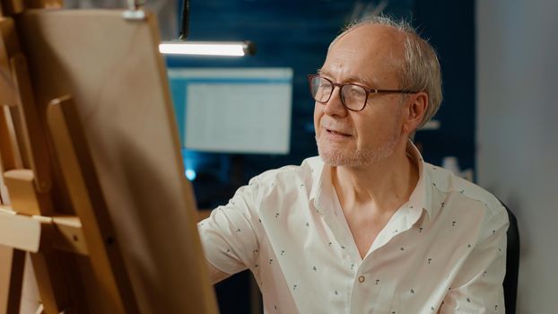 Retired man using artistic technique and pencils to draw masterpiece