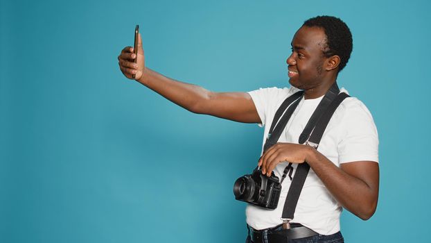 Photographer taking pictures using smartphone in studio