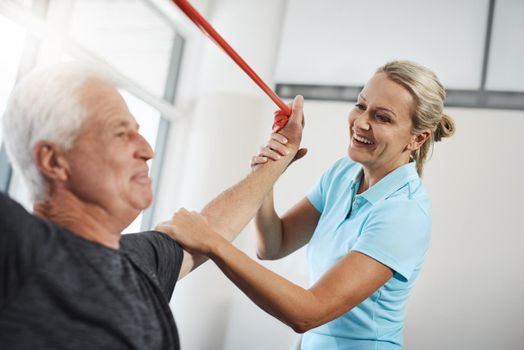 Your strength is impressive. a mature female physiotherapist working with a senior male patient in her office.
