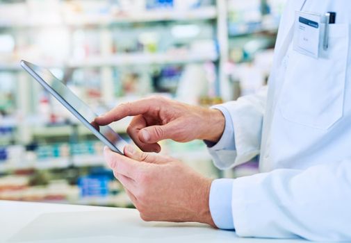 Computer technology helps pharmacies better manage their supplies. a pharmacist using a digital tablet in a pharmacy.