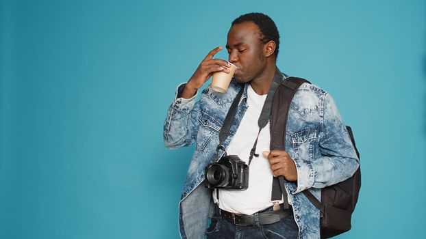 African american man with backpack working as photographer